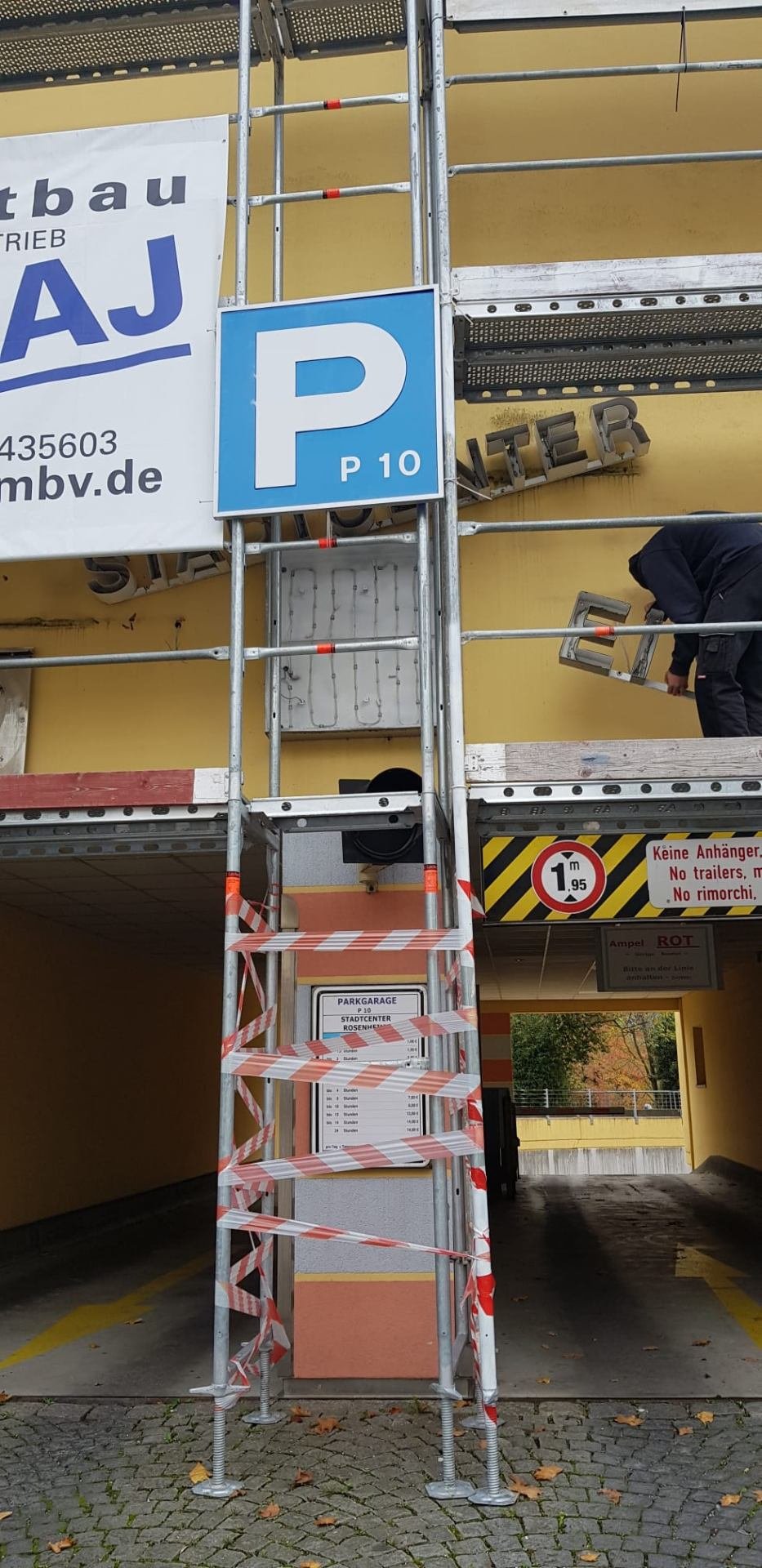 Montage einer Leuchtreklame auf Gerüst vor Ort